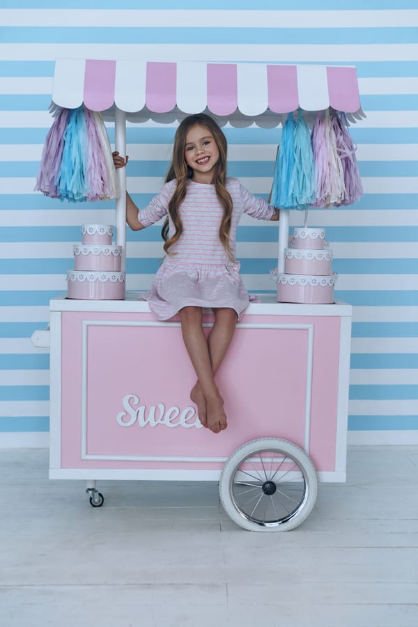 Hire candy cart — girl smiles on a pink sweet cart for parties and events in Johannesburg, Sandton and Randburg