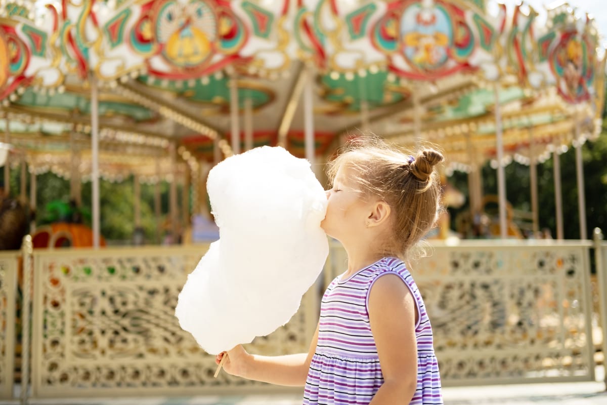 Candy Floss Machine hire — girl enjoying cotton candy at fun fair | Panda Party Hire Hire candy floss machine — girl enjoying cotton candy at fun fair for parties and events in Johannesburg, Sandton and Randburg