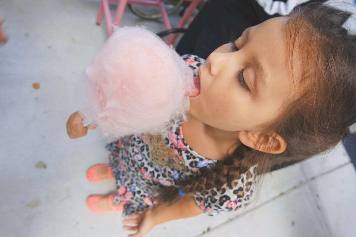 Candy Floss Machine hire — girl enjoys cotton candy treat outdoors | Panda Party Hire Hire candy floss machine — girl enjoys cotton candy treat outdoors for parties and events in Johannesburg, Sandton and Randburg