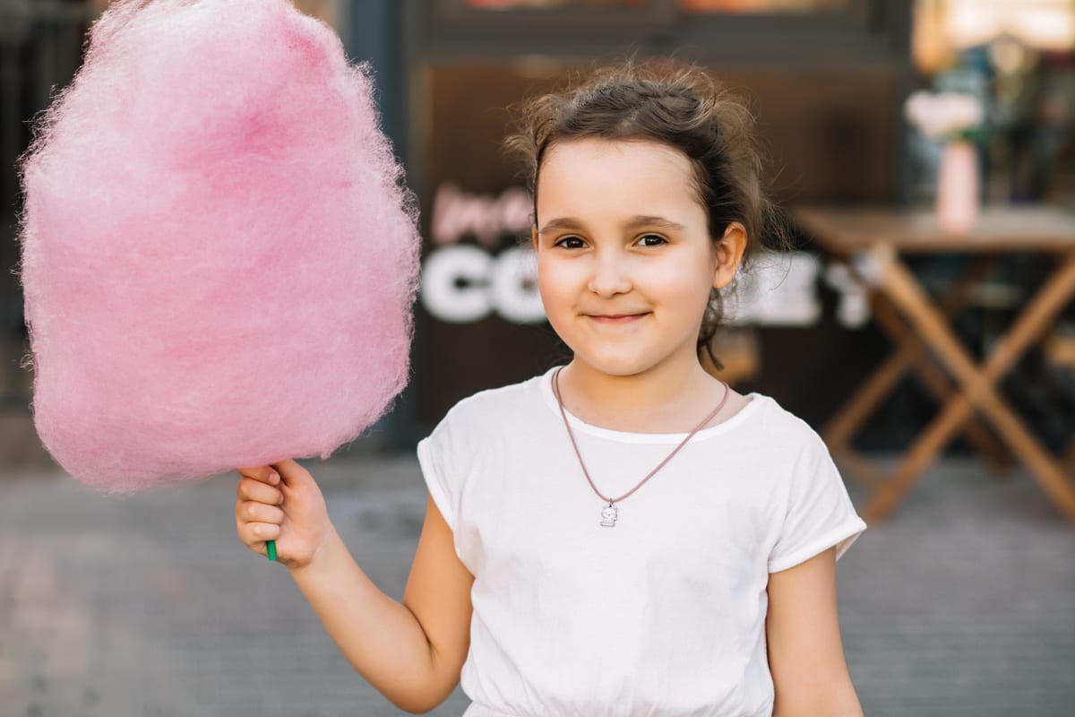 Candy Floss Machine hire — smiling girl with fluffy pink cotton candy treat | Panda Party Hire Hire candy floss machine — smiling girl with fluffy pink cotton candy treat for parties and events in Johannesburg, Sandton and Randburg