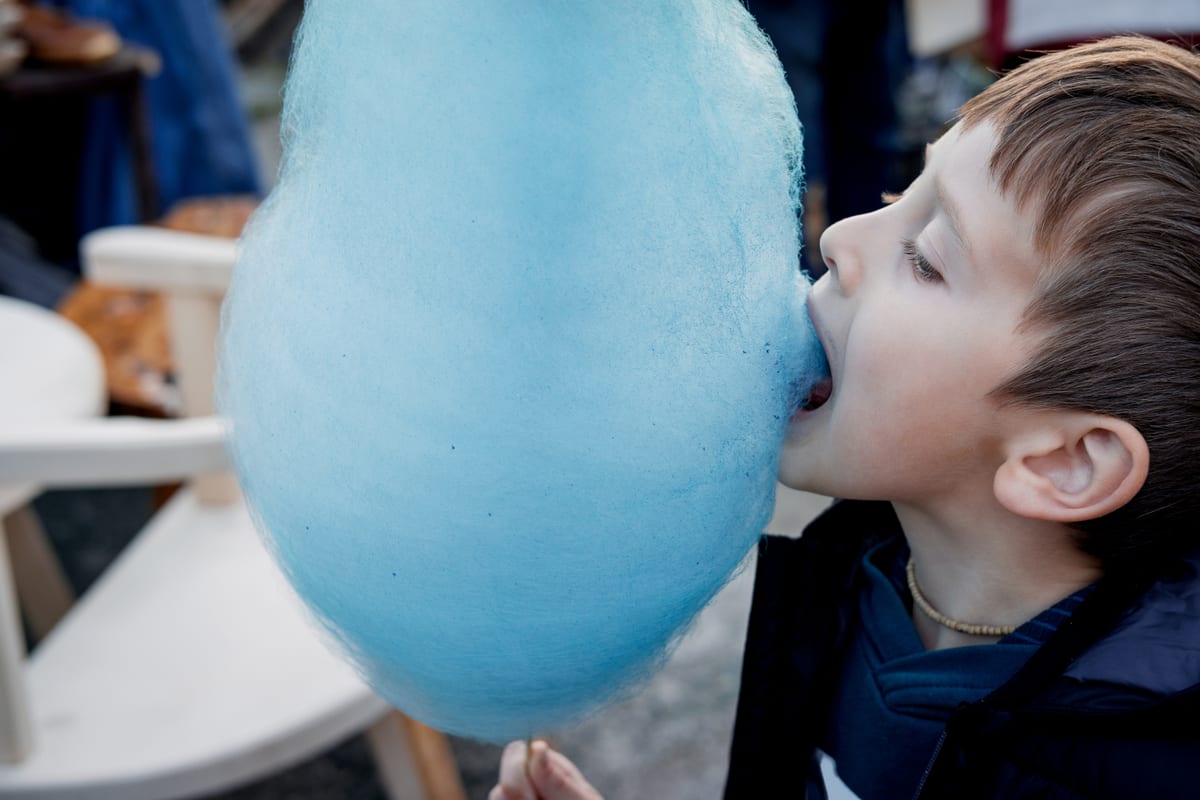 Candy Floss Machine hire — young boy eating blue cotton candy outdoors | Panda Party Hire Hire candy floss machine — young boy eating blue cotton candy outdoors for parties and events in Johannesburg, Sandton and Randburg