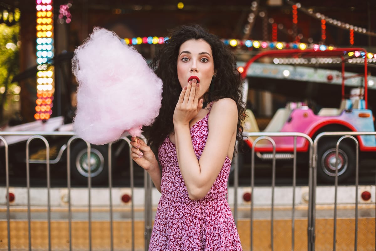 Candy Floss Machine hire — pretty lady in dress holding cotton candy amazedly | Panda Party Hire Hire candy floss machine — pretty lady in dress holding cotton candy amazedly for parties and events in Johannesburg, Sandton and Randburg