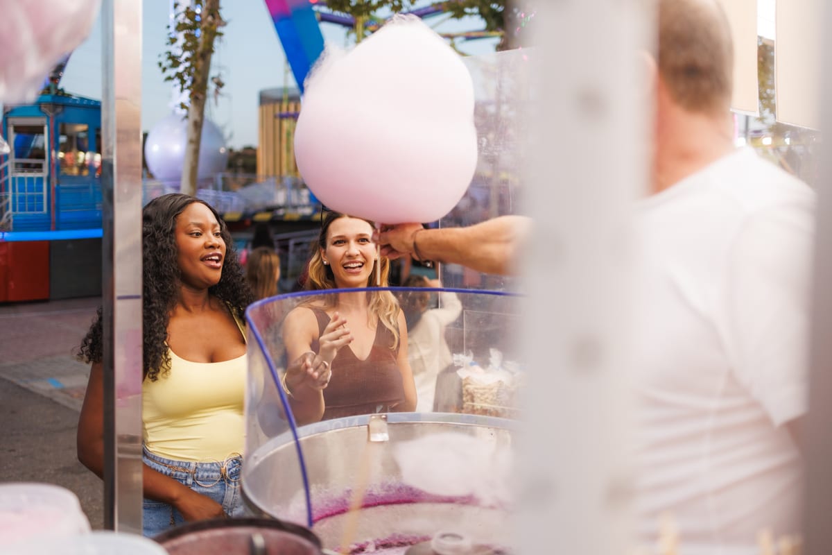 Candy Floss Machine hire — two smiling women at outdoor carnival buying cotto | Panda Party Hire Hire candy floss machine — two smiling women at outdoor carnival buying cotto for parties and events in Johannesburg, Sandton and Randburg