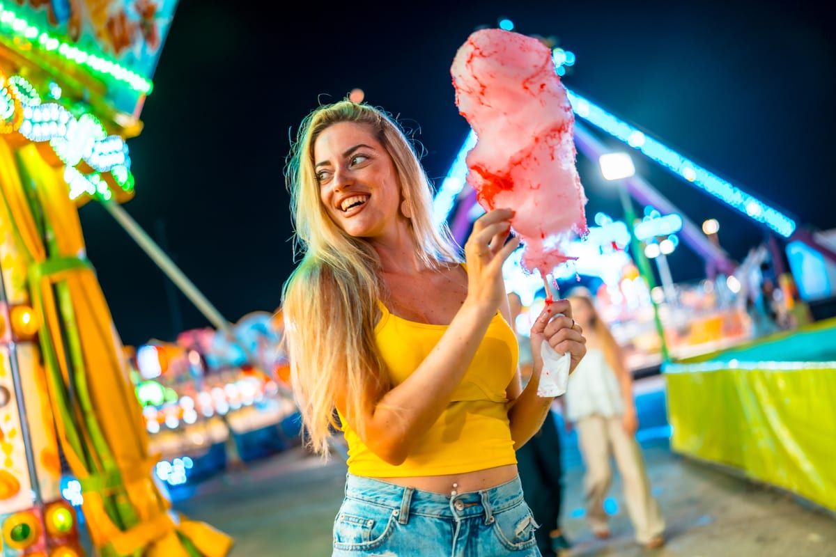 Candy Floss Machine hire — young woman enjoying cotton candy at night | Panda Party Hire Hire candy floss machine — young woman enjoying cotton candy at night for parties and events in Johannesburg, Sandton and Randburg