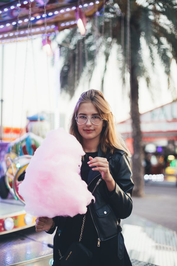Candy Floss Machine hire — young woman with cotton candy at a fair | Panda Party Hire Hire candy floss machine — young woman with cotton candy at a fair for parties and events in Johannesburg, Sandton and Randburg