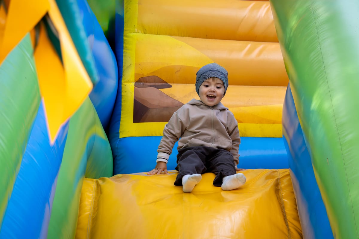 Hire jumping castle — happy toddler on a colorful inflatable slide for parties and events in Johannesburg, Sandton and Randburg