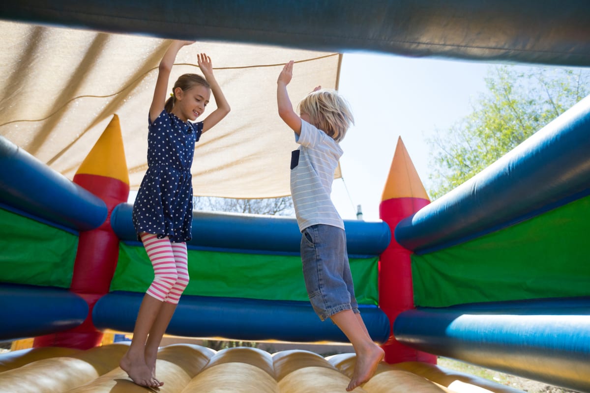 Hire jumping castle — happy siblings jumping on bouncy castle for parties and events in Johannesburg, Sandton and Randburg