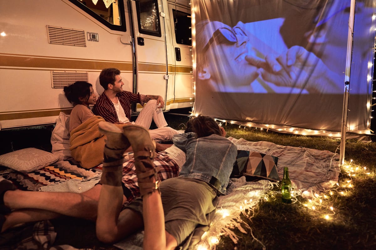 Hire outdoor cinema — friends watching movie outside by a motorhome for parties and events in Johannesburg, Sandton and Randburg
