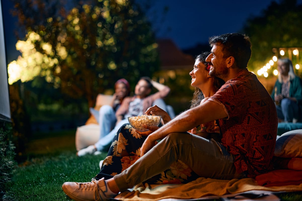 Hire outdoor cinema — couple watching movie in backyard with friends for parties and events in Johannesburg, Sandton and Randburg