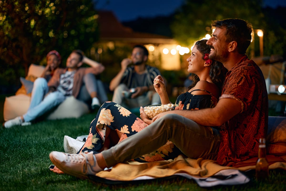 Hire outdoor cinema — happy couple watching a movie in the yard for parties and events in Johannesburg, Sandton and Randburg