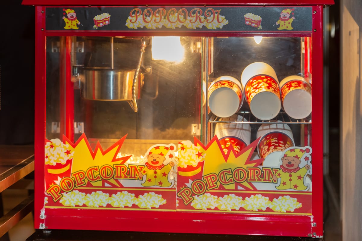 Popcorn machine hire — classic red hire machine | Panda Party Hire Hire popcorn machine — classic red vintage-style popcorn machine stocked with cups and ready for party delivery
