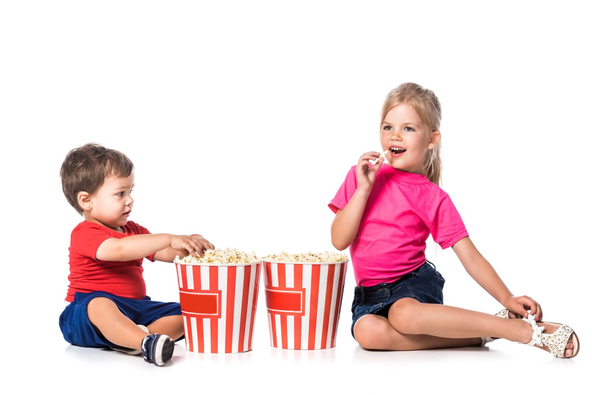 Popcorn machine hire — kids enjoying popcorn at party | Panda Party Hire Hire popcorn machine — young children enjoying striped popcorn buckets at a family party and school fete