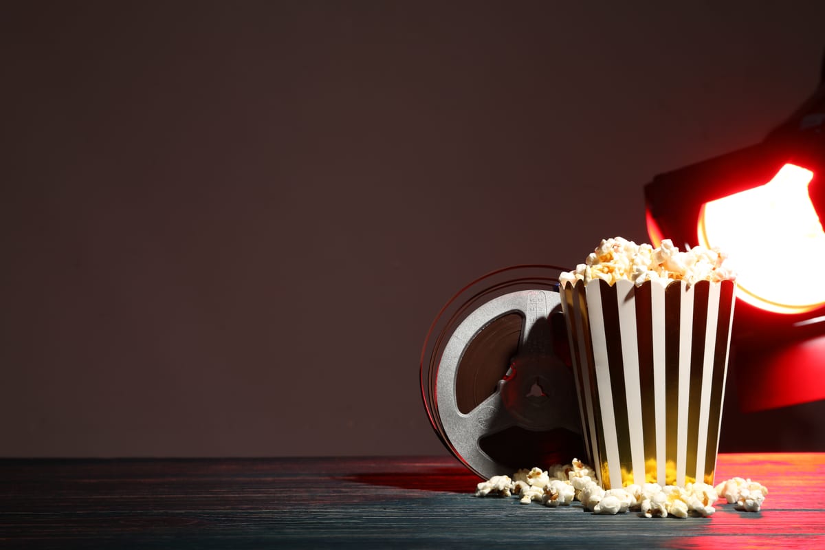 Popcorn machine hire — striped buckets party setup | Panda Party Hire Hire popcorn machine — red and white striped popcorn buckets beside a commercial machine at an event