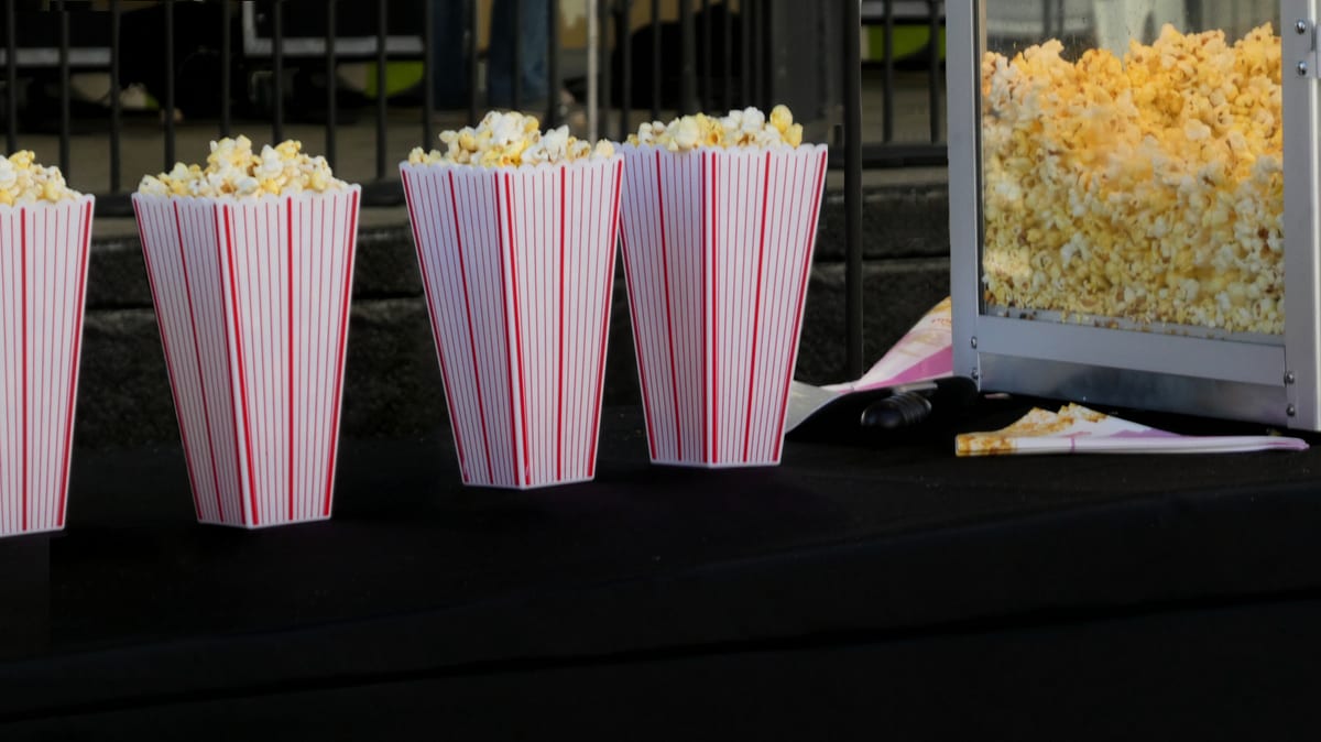 Popcorn machine hire — cinema birthday party cups | Panda Party Hire Hire popcorn machine — multiple popcorn cups ready for guests at a cinema-themed birthday party