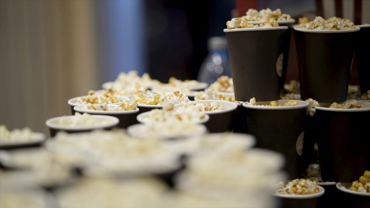 Popcorn machine hire — caramel popcorn party display | Panda Party Hire Hire popcorn machine — caramel popcorn in striped buckets on a wooden table for party catering hire
