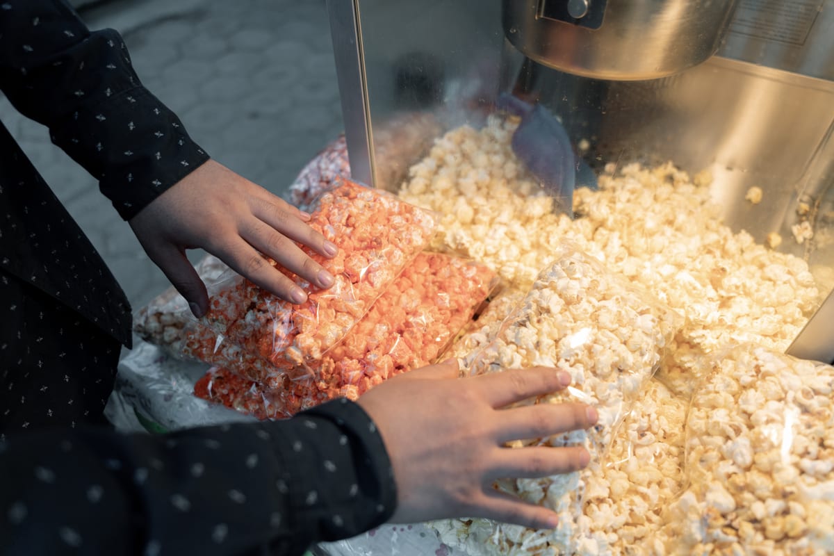 Popcorn Machine hire — a young hispanic adult is looking at some popcorn | Panda Party Hire Hire popcorn machine — a young hispanic adult is looking at some popcorn for parties and events in Johannesburg, Sandton and Randburg