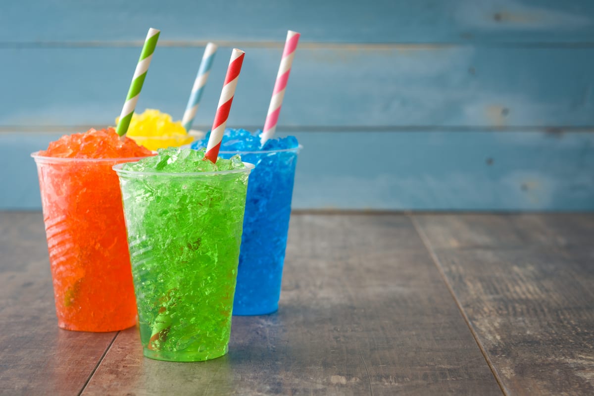 Slush Machine hire — colorful frozen drinks with striped straws on wood | Panda Party Hire Hire slush machine — colorful frozen drinks with striped straws on wood for parties and events in Johannesburg, Sandton and Randburg