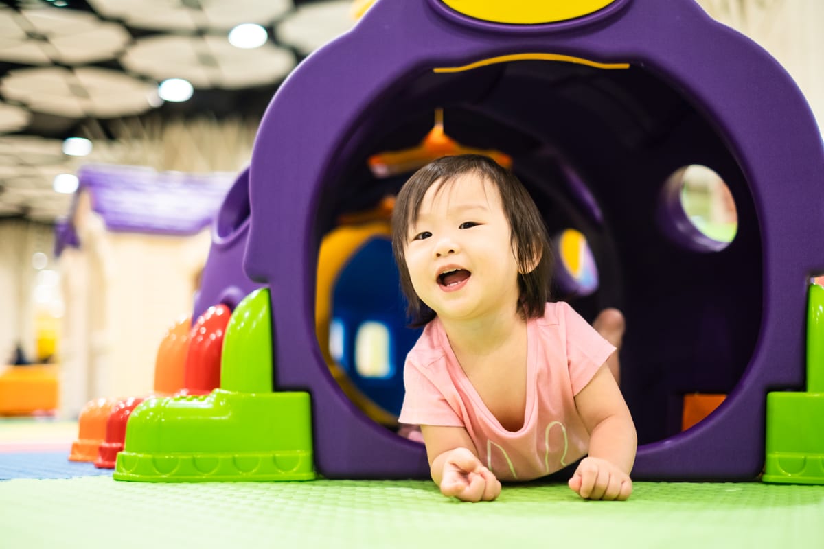 Hire soft play equipment — little cute asian toddler girl crawling out from c for parties and events in Johannesburg, Sandton and Randburg
