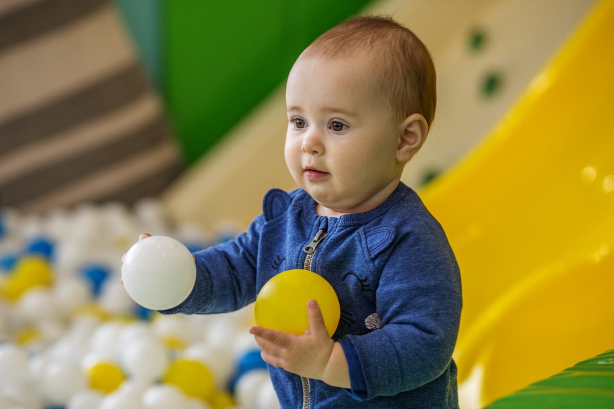 Hire soft play equipment — baby holding colorful plastic balls at play center for parties and events in Johannesburg, Sandton and Randburg