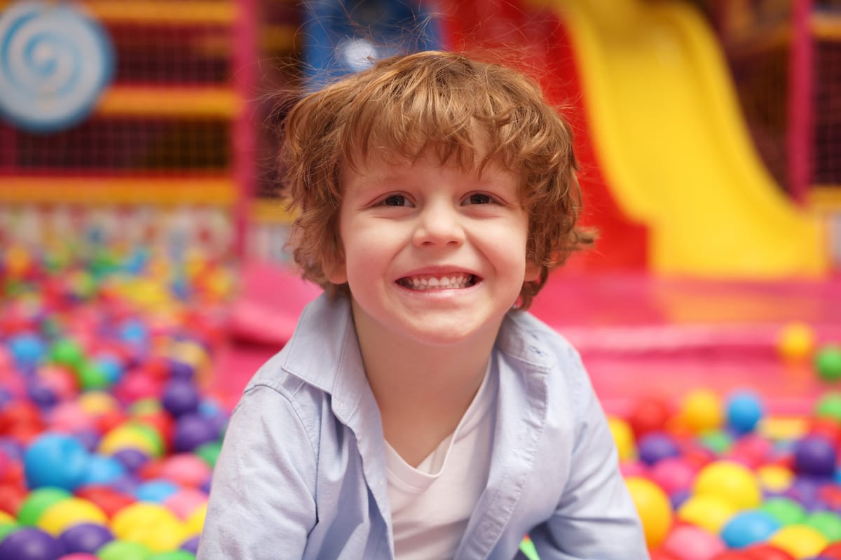 Hire soft play equipment — smiling boy poses in colorful ball pit for parties and events in Johannesburg, Sandton and Randburg