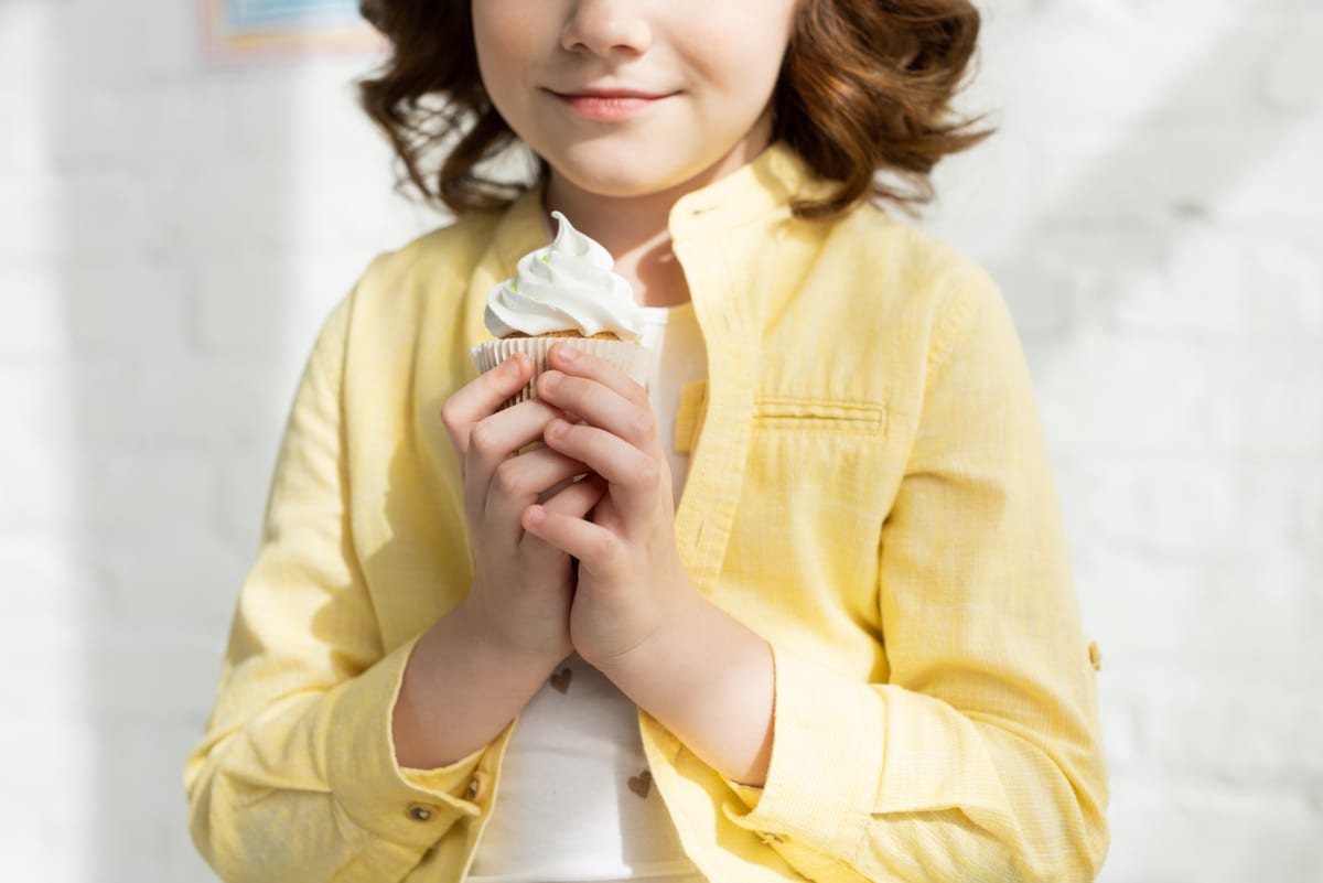 Hire soft serve machine — cropped view of kid in yellow holding delicious cu for parties and events in Johannesburg, Sandton and Randburg