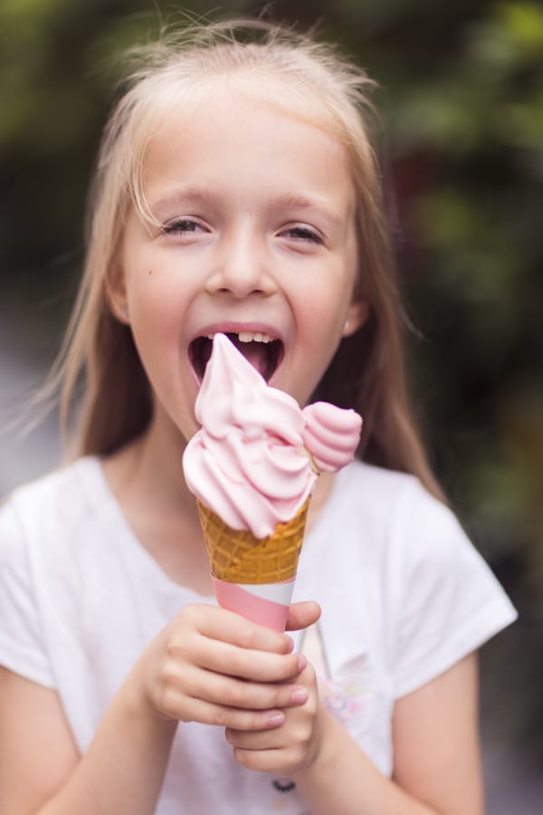 Hire soft serve machine — happy girl eating pink ice cream cone outdoors for parties and events in Johannesburg, Sandton and Randburg