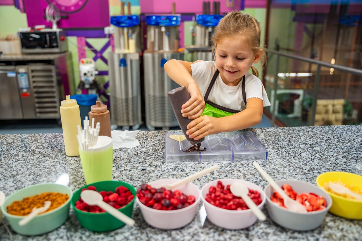 Hire soft serve machine — girl pouring chocolate into mold at candy shop for parties and events in Johannesburg, Sandton and Randburg